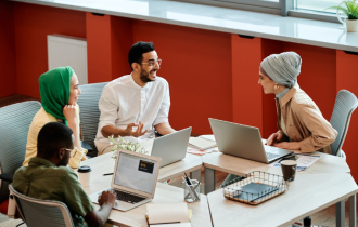 Smiling Group of Diverse People Sitting Around a Conference Table