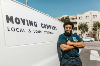 African American Man Standing Next to a Moving Truck