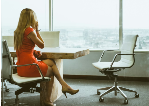 Professional Woman with Long Blonde Hair Talking on the Phone While Looking Out a Window
