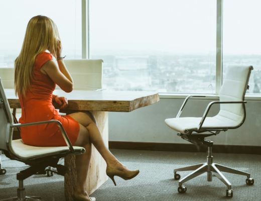 Professional Woman with Long Blonde Hair Talking on the Phone While Looking Out a Window