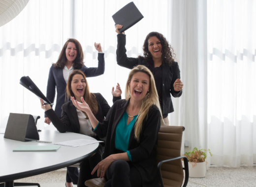 4 Happy and Smiling Business Women in an Office