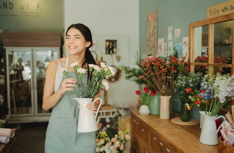 Woman Holding a Vase of Flowers in a Flower Shop