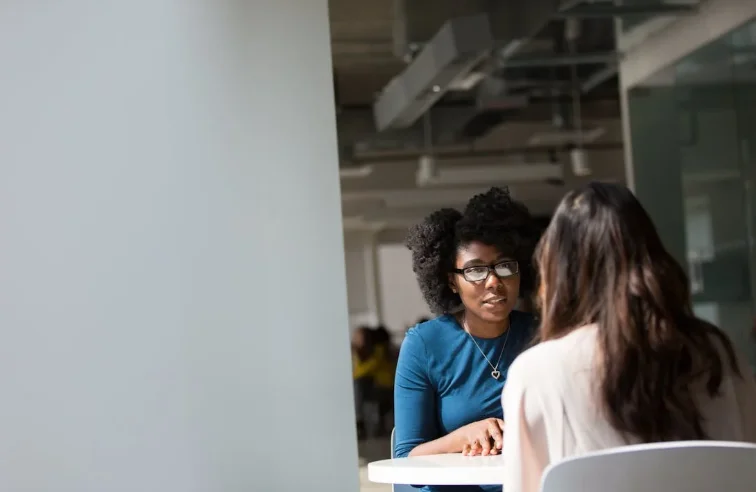 2 Woman Sitting at an Conference Table