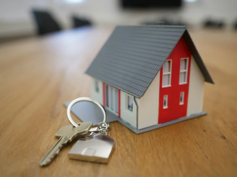 Replica of a House Sitting Next to a House Key