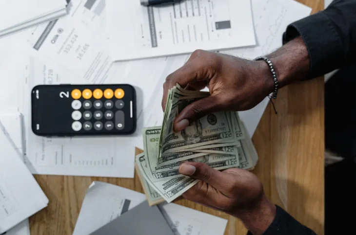 Woman Sitting at a Desk and Counting Money