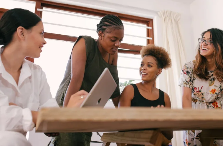 A Group of Coworkers Huddled Around a Desk